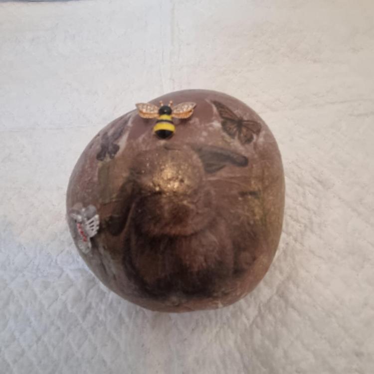 Front view of brown weighted doorstop with bunny and bee image